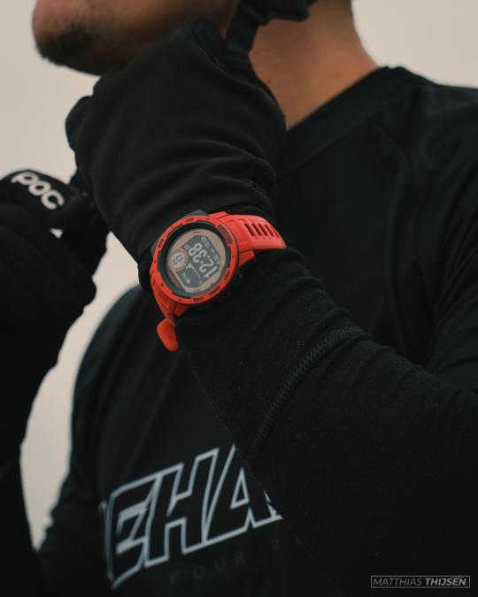 A red sport watch on the wrist of a biker.