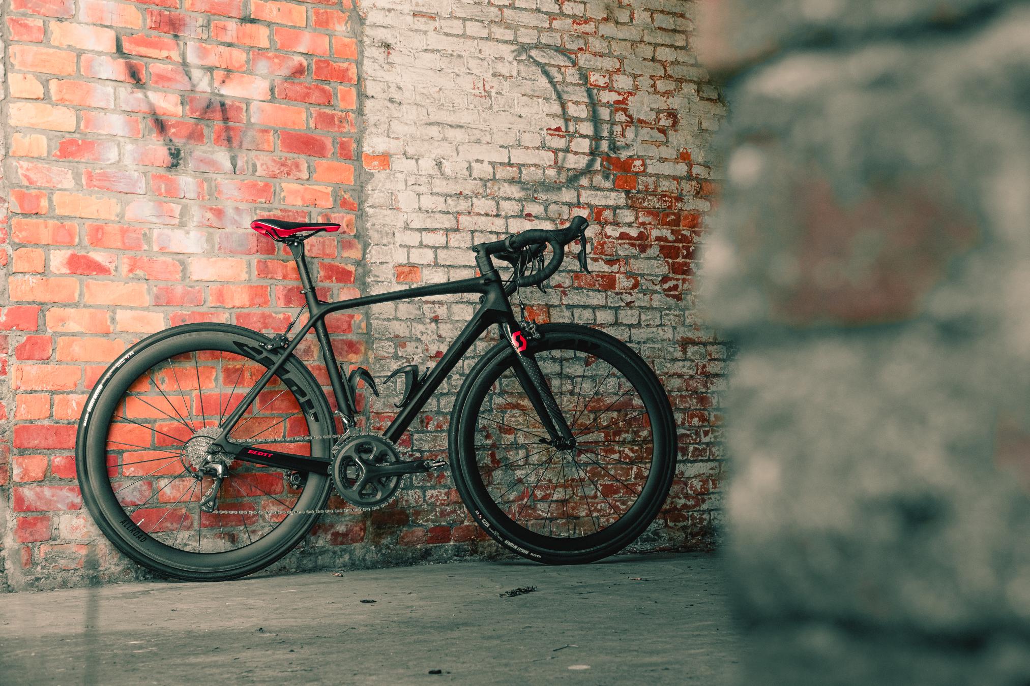 A bike standing against a brick wall.